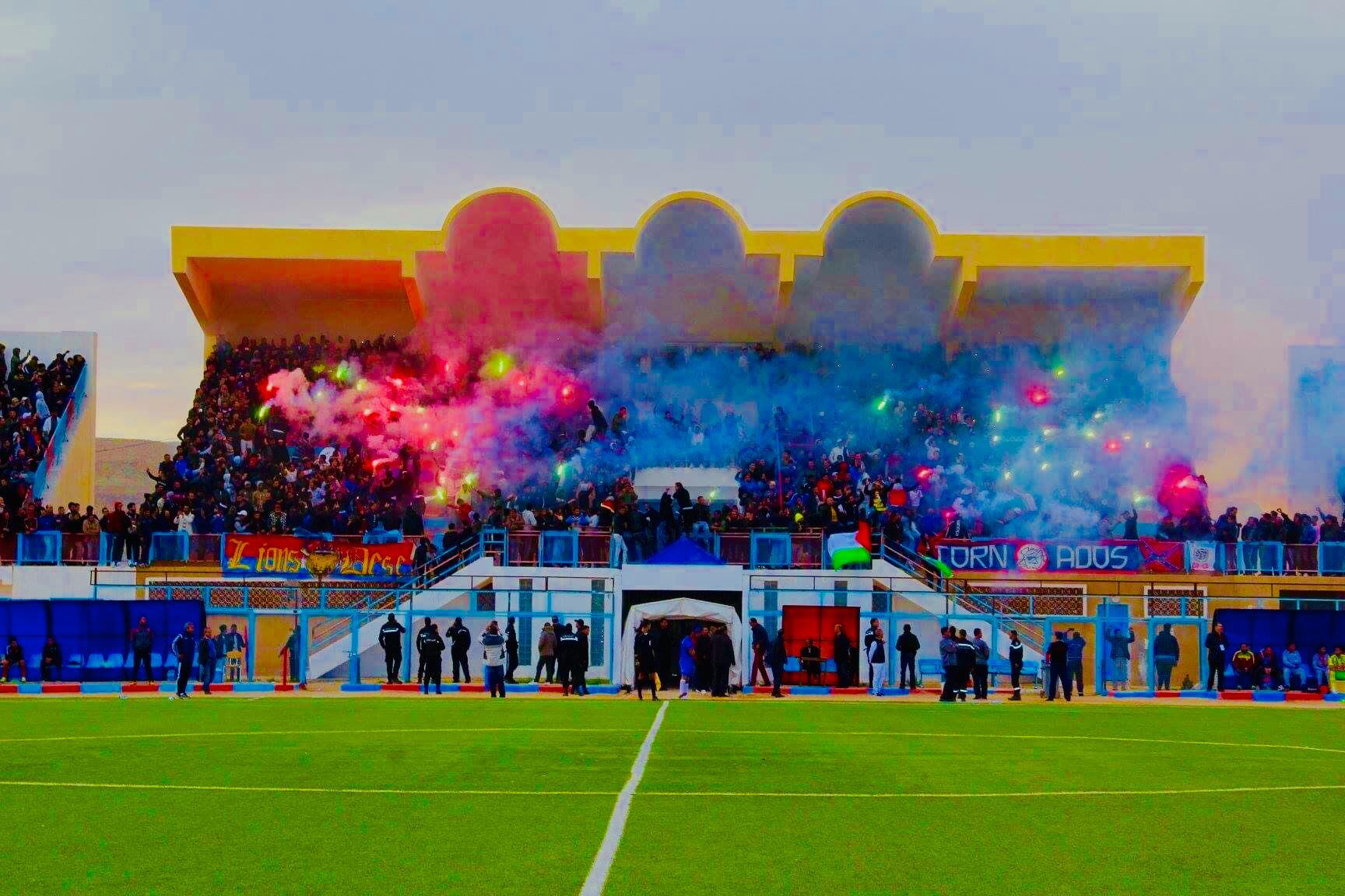 Tifo des supporters de l'UST avec fumigènes rouges et bleus dans les tribunes du Stade Najib Khatab de Tataouine